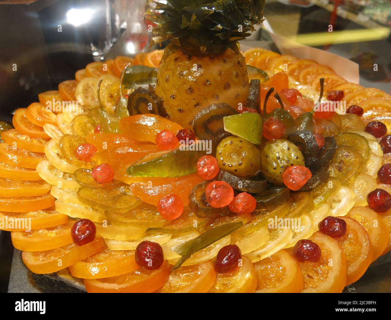 A platter of glacé fruits in a display cabinet at Les Halles de Lyon - Paul Bocuse, a haven for French cuisine. Stock Photo