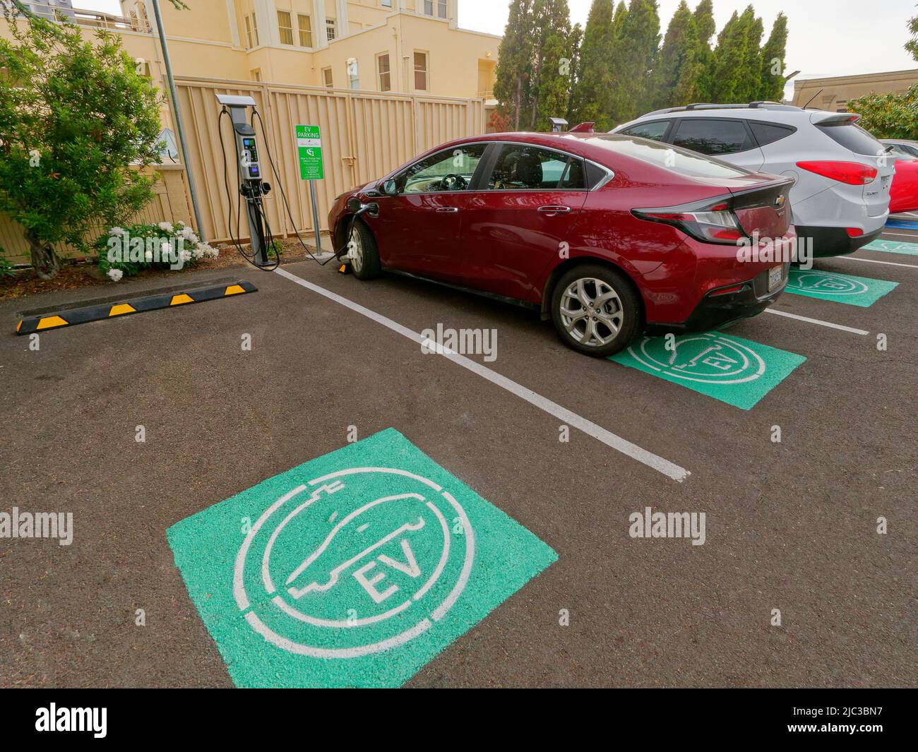 In Ashland, Oregon, the hotel Ashland Springs provides four charging stations for electric vehicles. Symbol on parking space reserved for the electric cars (Chevrolet Volt seen charging) Stock Photo