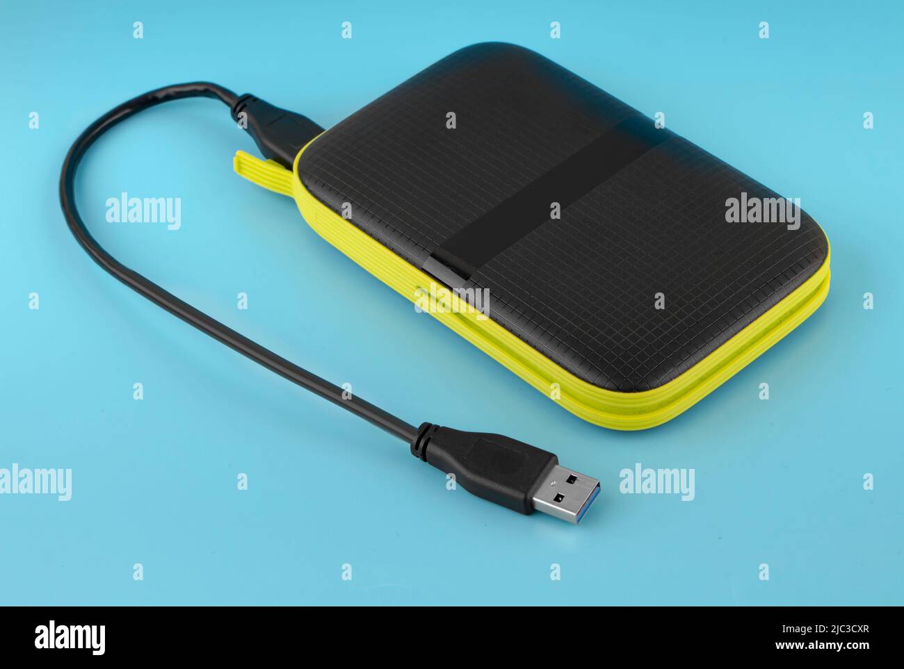 external hard drive, external drive with USB cable on a blue background Stock Photo