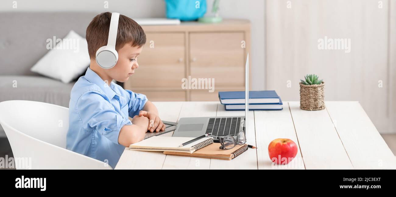 Little schoolboy studying online at home Stock Photo