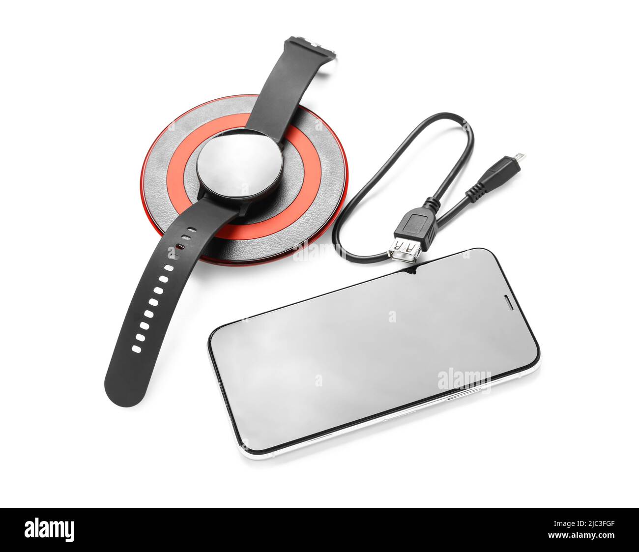 Wireless charger pad, smartwatch and mobile phone on white background ...