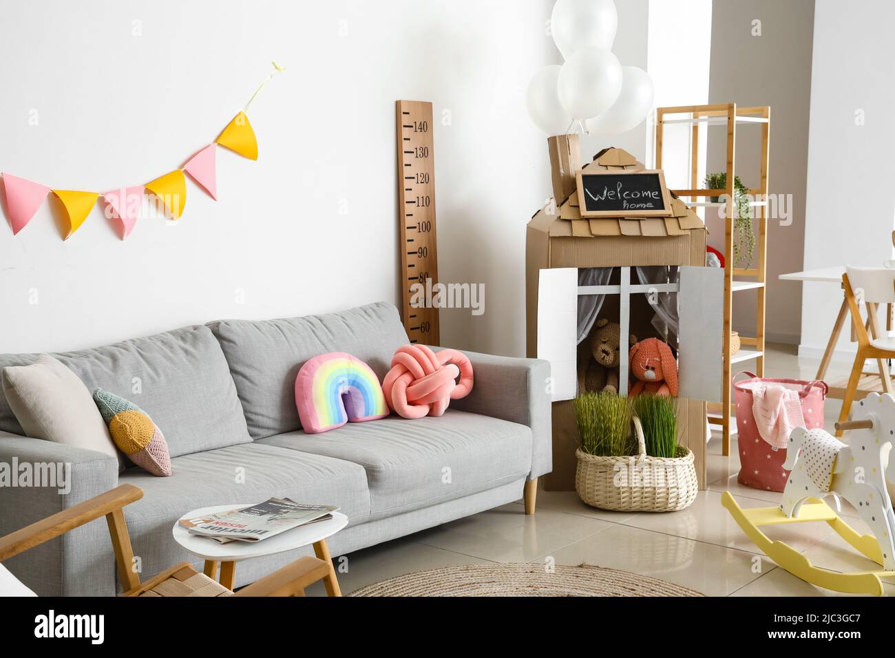 Interior of playroom with sofa, toys and cardboard house Stock Photo