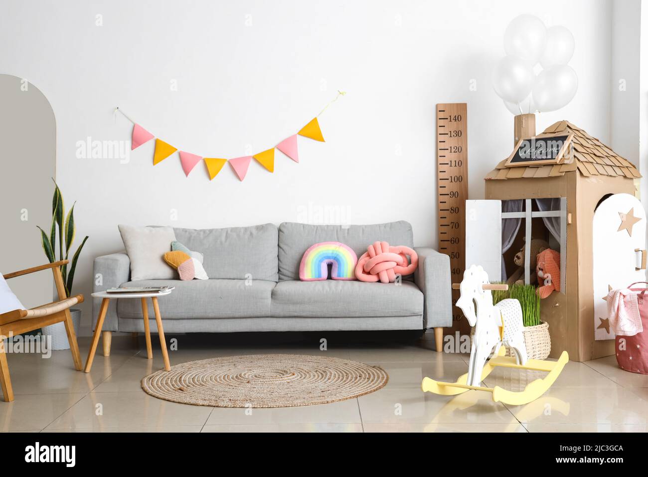 Interior of playroom with sofa, toys and cardboard house Stock Photo