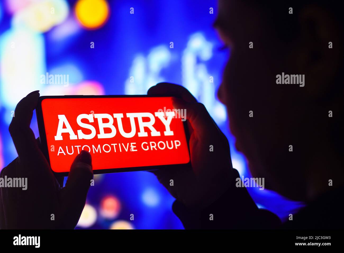 In this photo illustration, a silhouetted woman holds a smartphone with