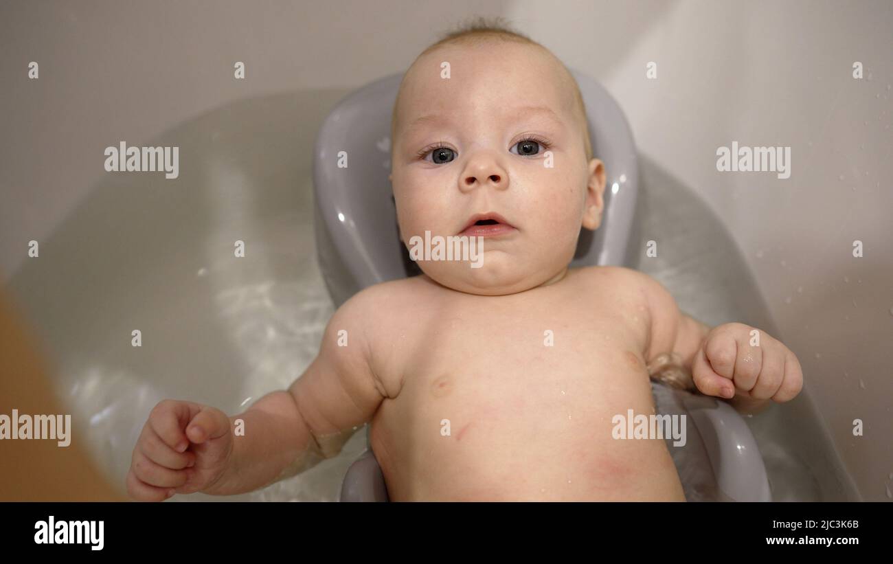 A little boy takes a bath for the first time. Portrait of an adorable
