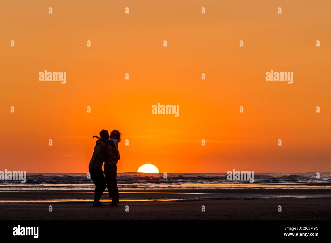 Silhouette of couple kissing at the sunset on the beach Stock Photo - Alamy