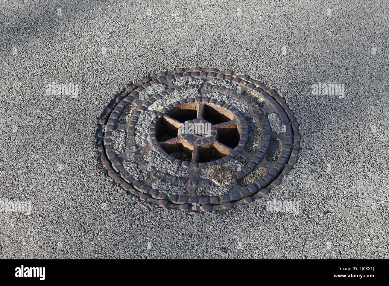 Drain man hole cover in pavement Stock Photo