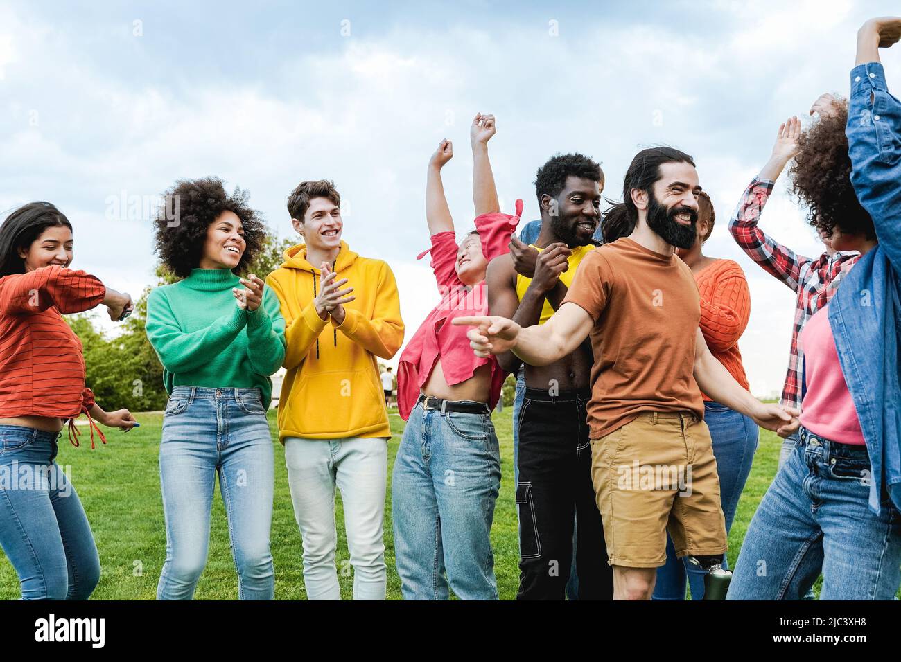 Diverse friends having fun dancing together outdoor - Diversity and multiethnic community concept - Focus on man with prosthetic leg Stock Photo