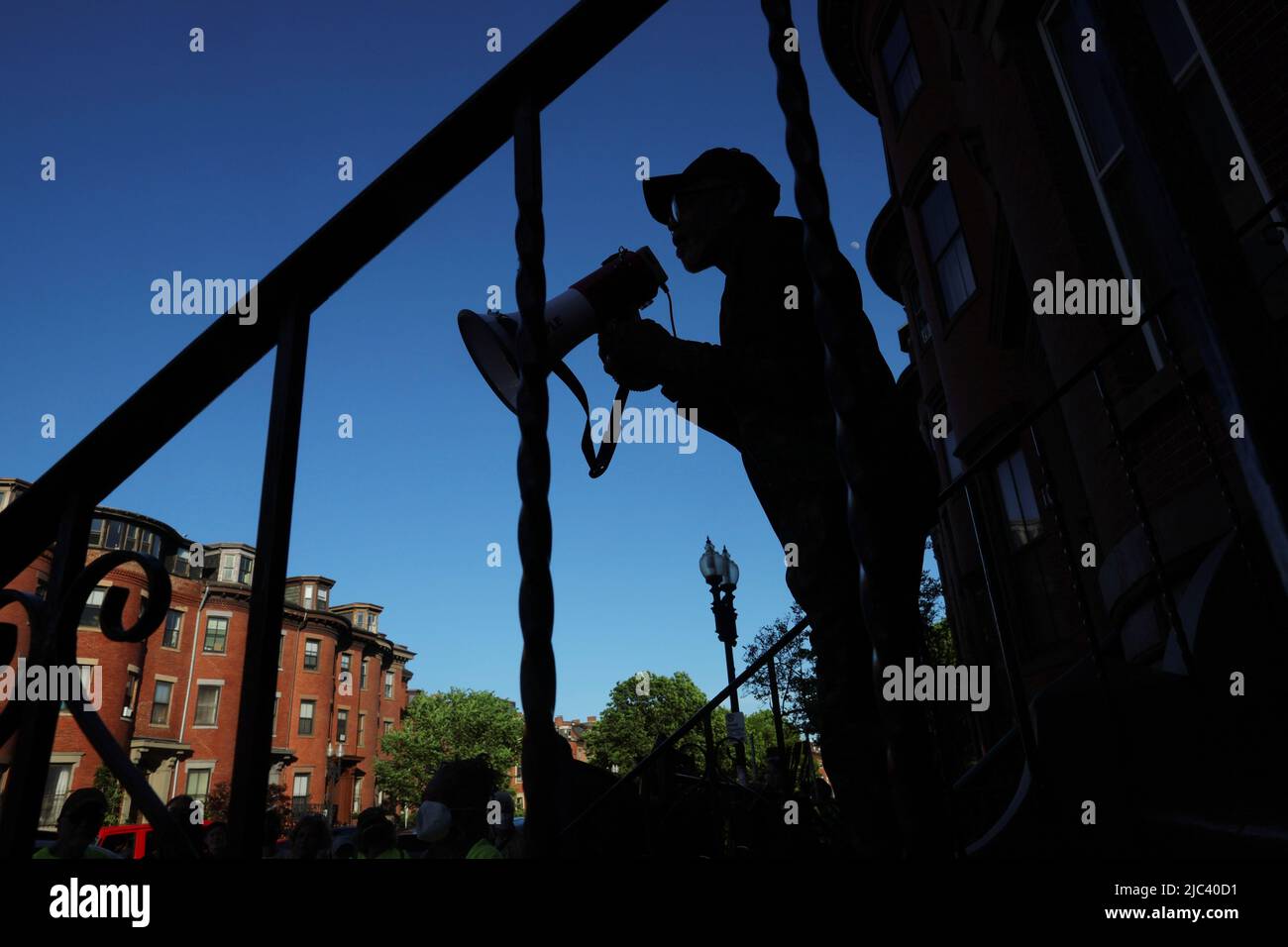 James Harrison, the last tenant in his apartment building, speaks from the front stairs to activists holding a vigil to protest Harrison's no-fault eviction so that the owner of the building he has lived in for 30 years can sell it empty, in Boston, Massachusetts, U.S., June 9, 2022.   REUTERS/Brian Snyder Stock Photo
