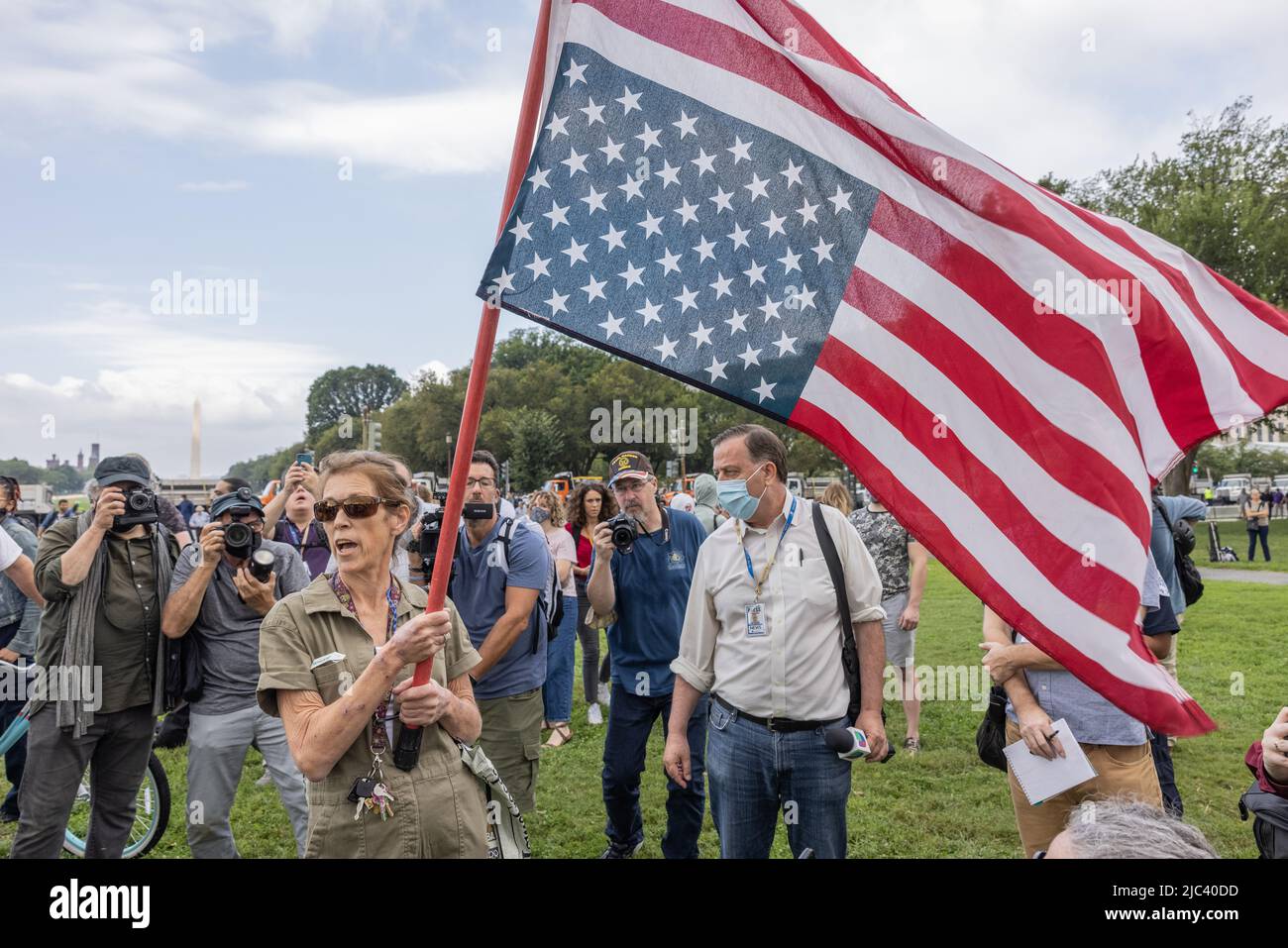 WASHINGTON, D.C. – September 18, 2021: A demonstrator waves a flag near members of the media before a “Justice for J6” rally. Stock Photo