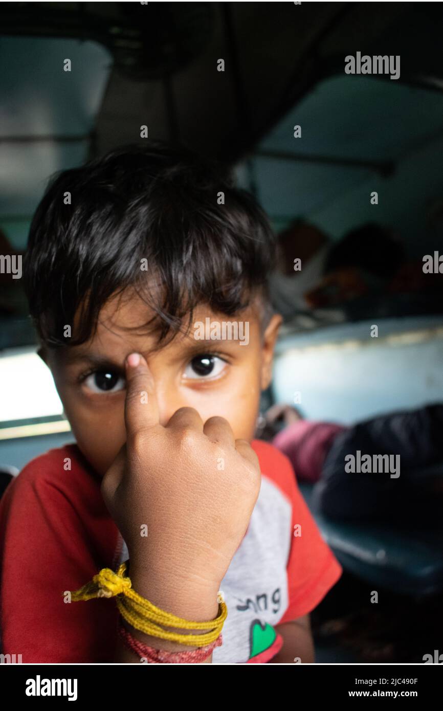 An Indian boy in train, enjoying the ride Stock Photo