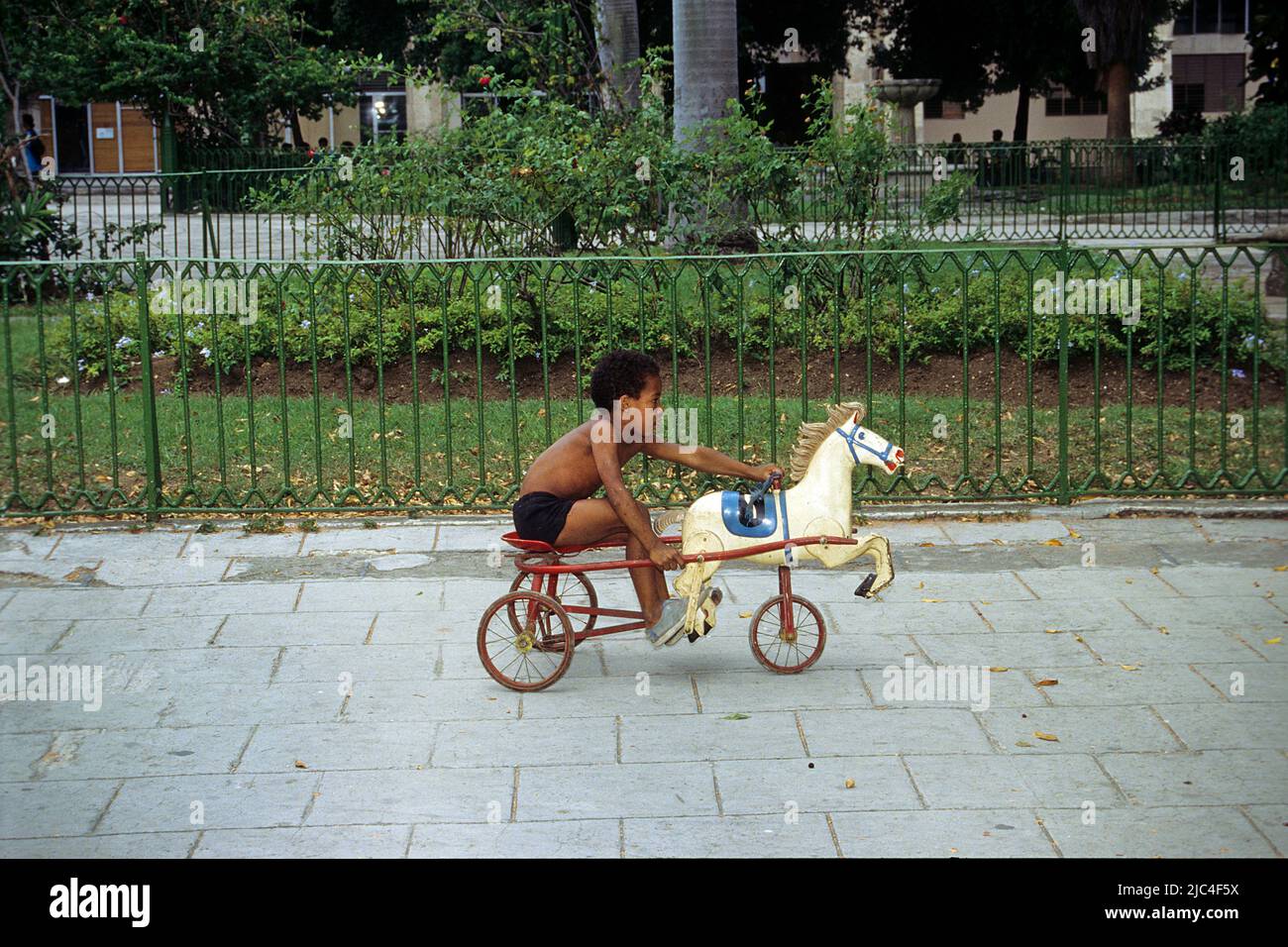 Cuban boy on a horse-drawn carriage with a wooden horse, Havana, Cuba, Caribbean Stock Photo