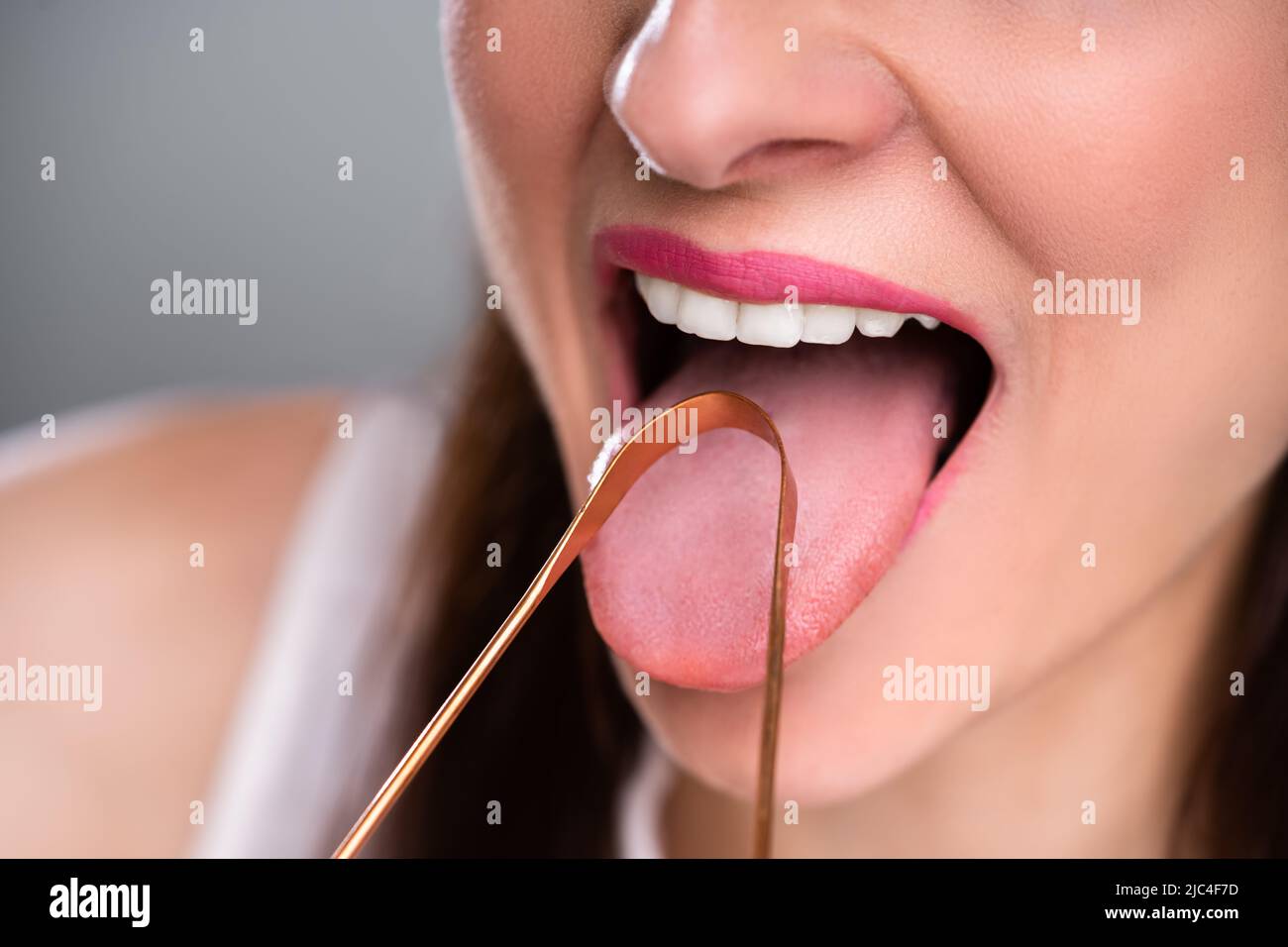 Close-up Of A Woman Cleaning Her Tongue With Cleaner Stock Photo