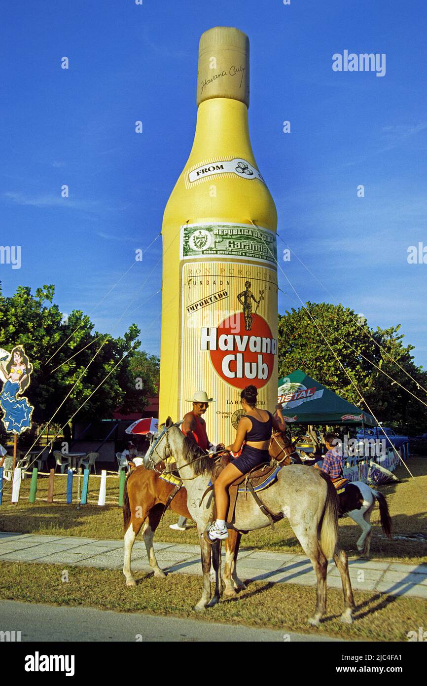 Rider on horse at a fiesta, big plastic Havana Club rum bottle, St. Lucia, Cuba, Caribbean Stock Photo