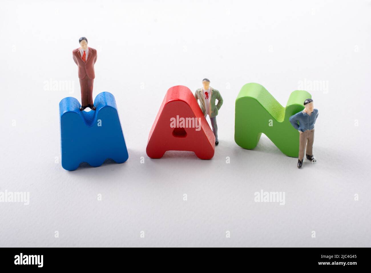 Tiny figurine of men beside colorful wooden letters say MAN Stock Photo ...