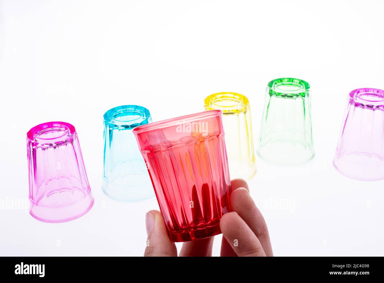 https://c8.alamy.com/comp/2JC4G98/colorful-drinking-glass-in-hand-with-glasses-on-white-background-2JC4G98.jpg
