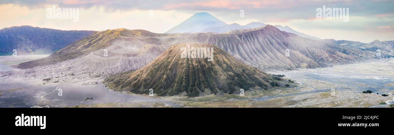 View from above, stunning panoramic view of the Mount Batok, Mount Bromo and the Mount Semeru in the distance illuminated at sunrise. Stock Photo