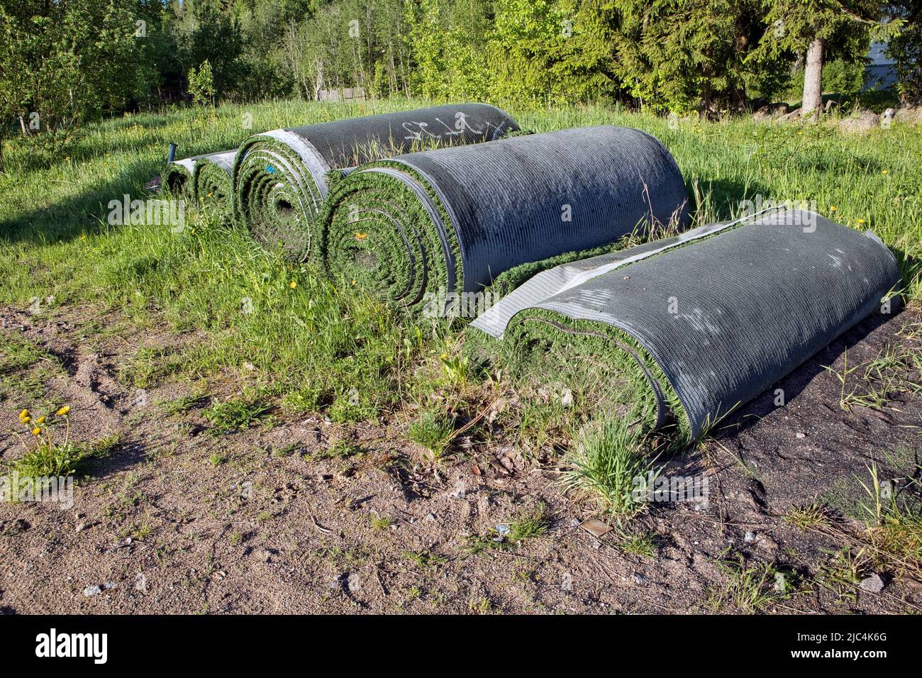 Rolls of old artificial grass outdoors Stock Photo