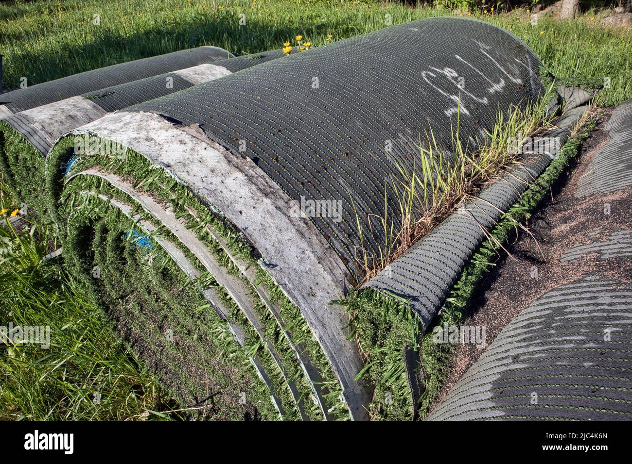 Rolls of old artificial grass outdoors Stock Photo