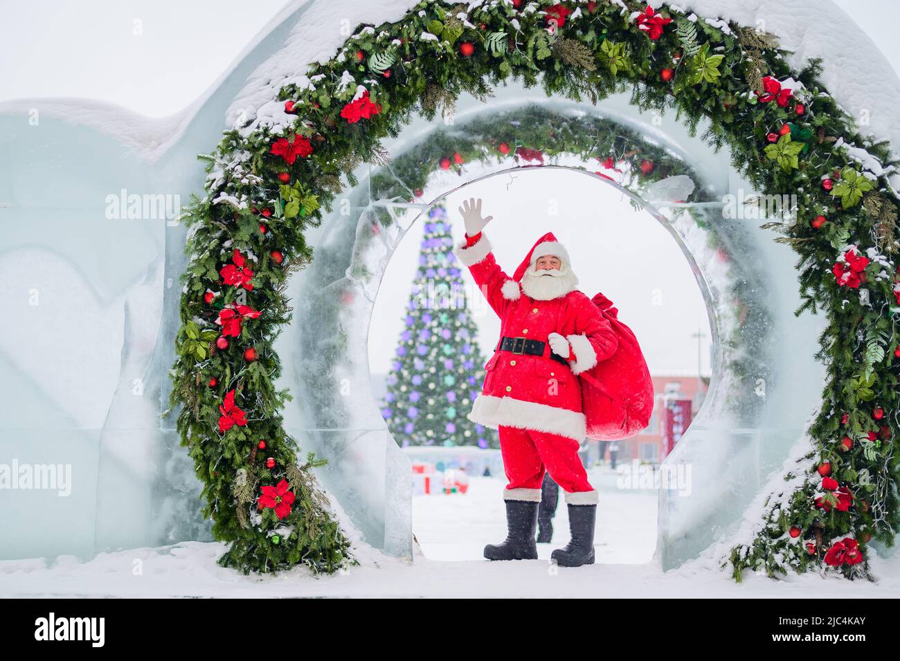 Santa Claus posing with a bag of gifts on the background of Christmas ...