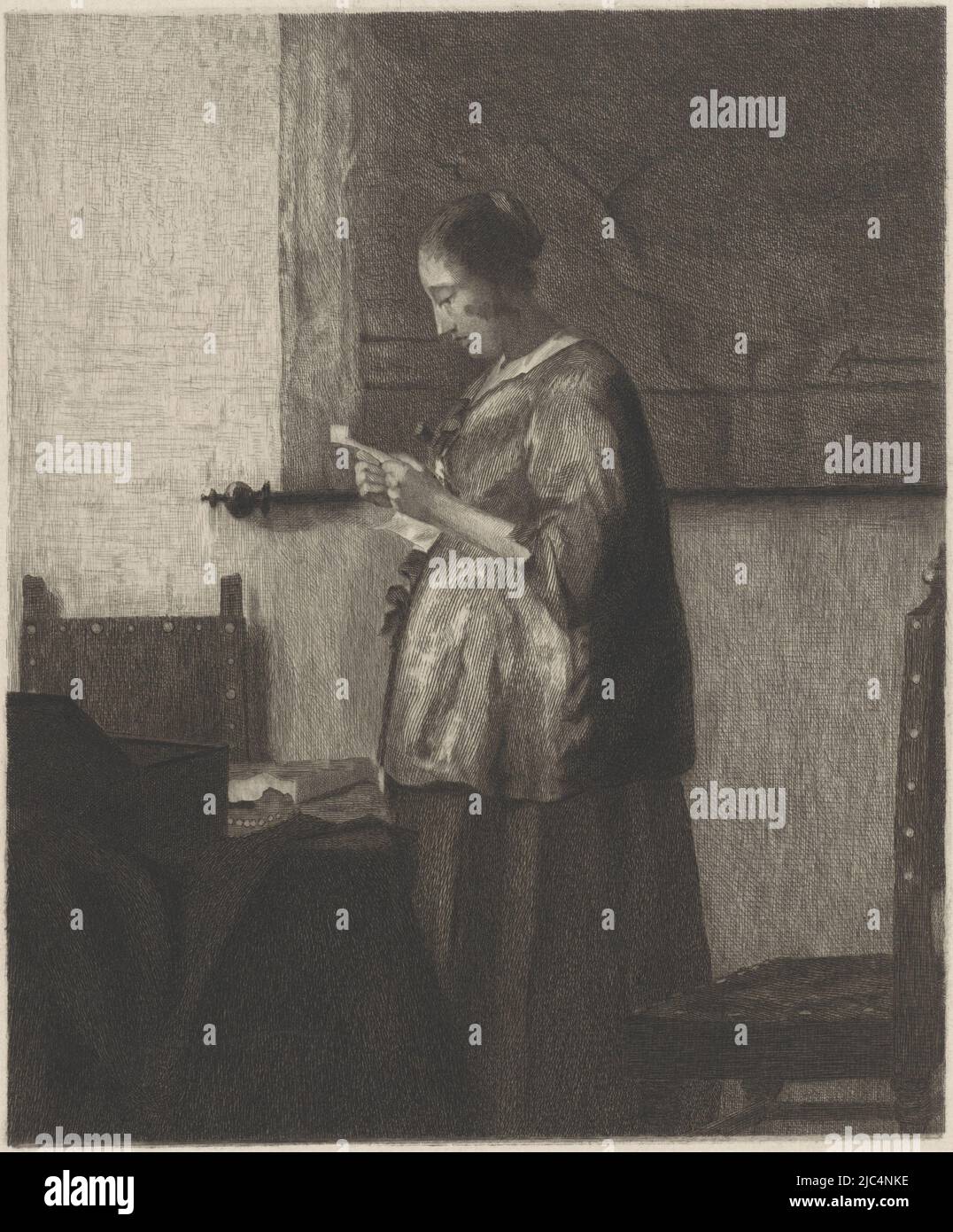 Letter Reading Woman. A young woman, standing by a table with chairs, reads a letter. Behind her on the wall is a map on scrolls., Letter Reading Woman, print maker: Willem Steelink (I), after: Johannes Vermeer, Netherlands, 1866 - 1928, paper, etching, engraving, h 197 mm × w 162 mm Stock Photo