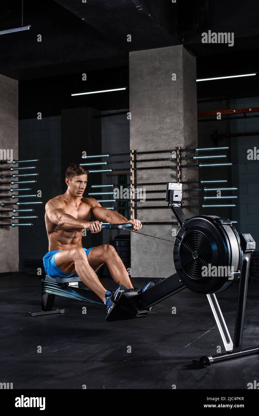 Bodybuilder working on his legs with weight machine at the gym Stock