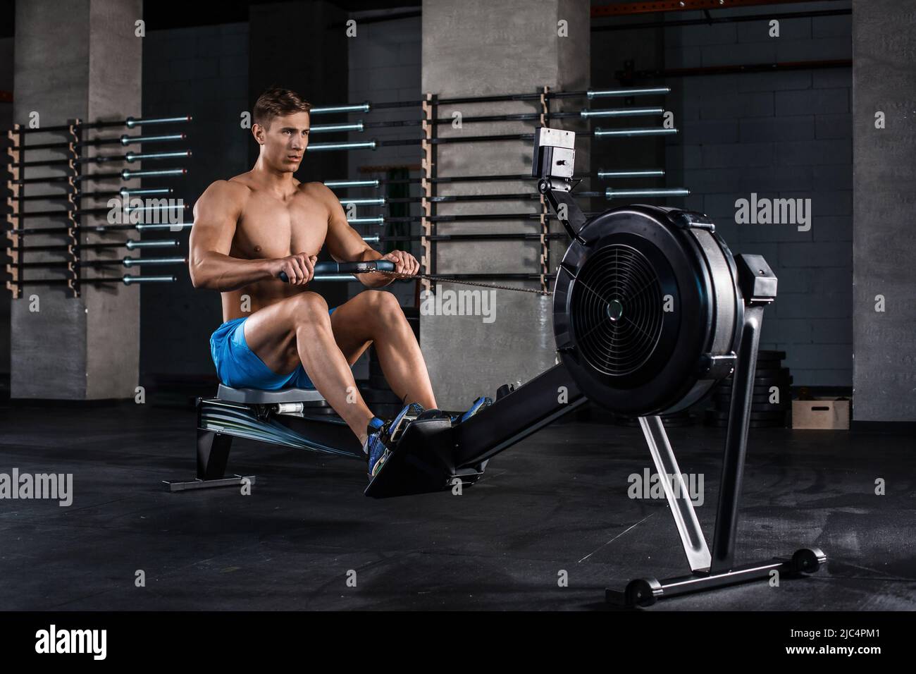 Bodybuilder working on his legs with weight machine at the gym Stock