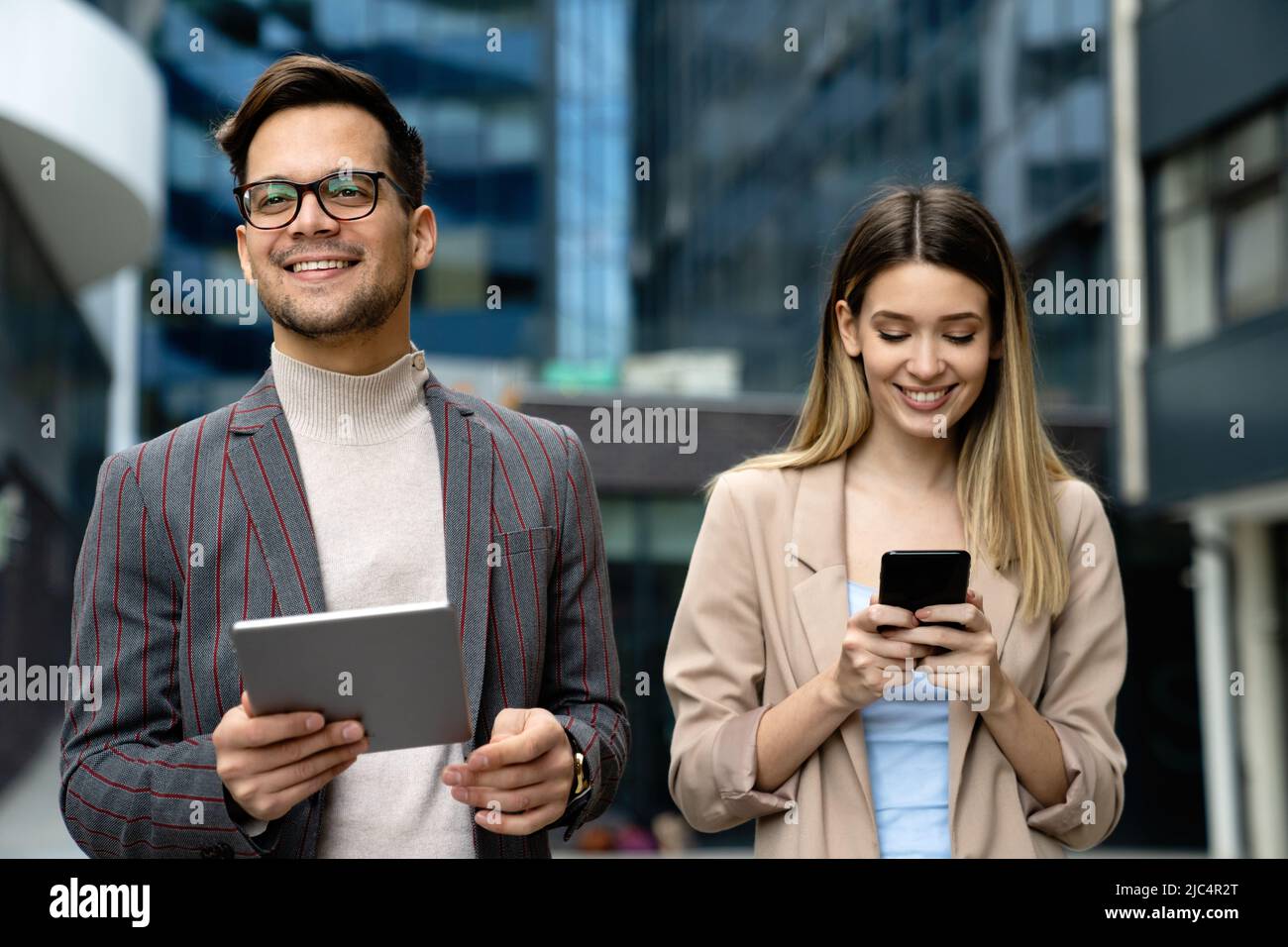 Portrait of successful business people working, talking together in urban background. Stock Photo