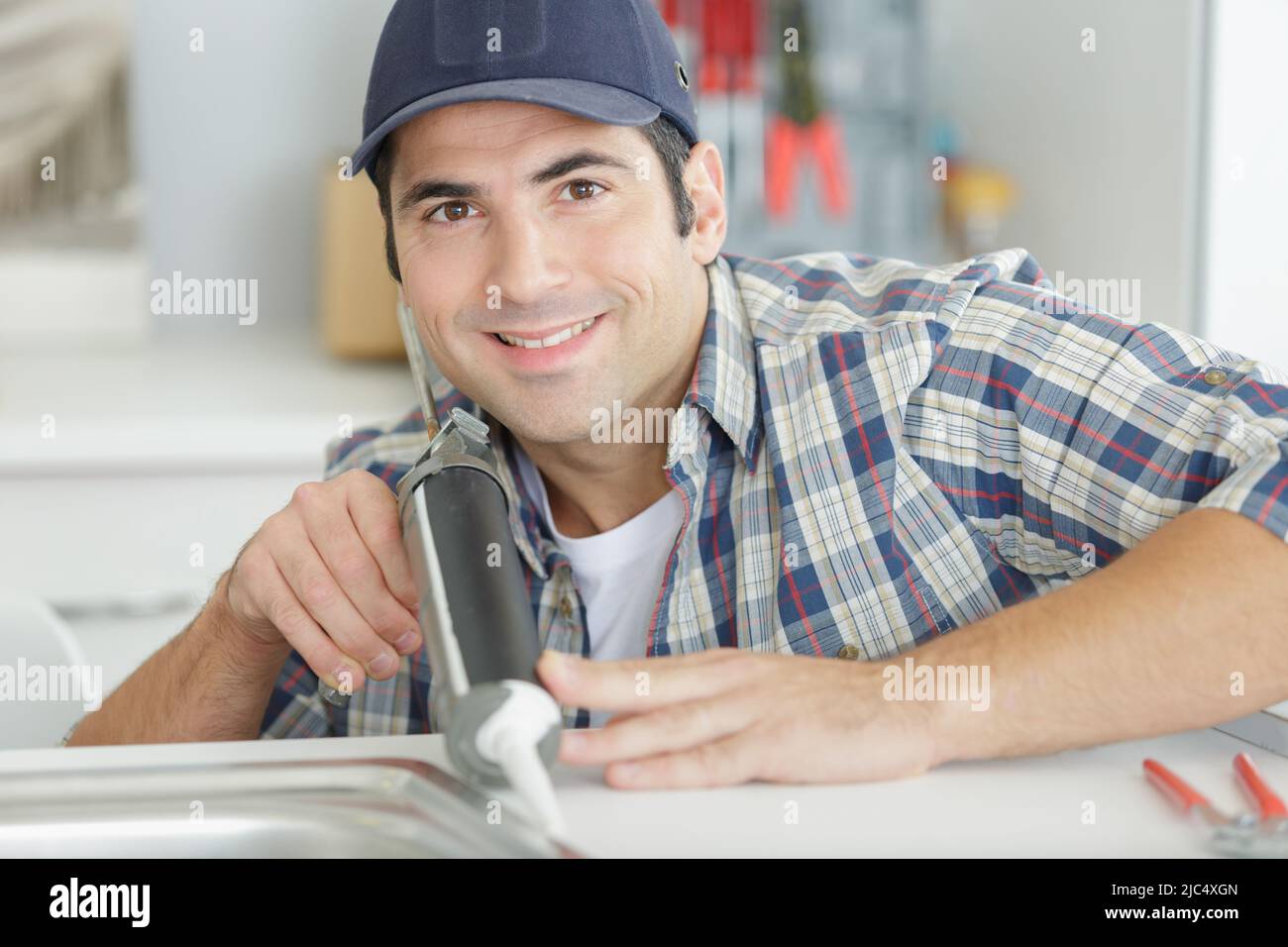 plumber sealing sink with silicone Stock Photo Alamy