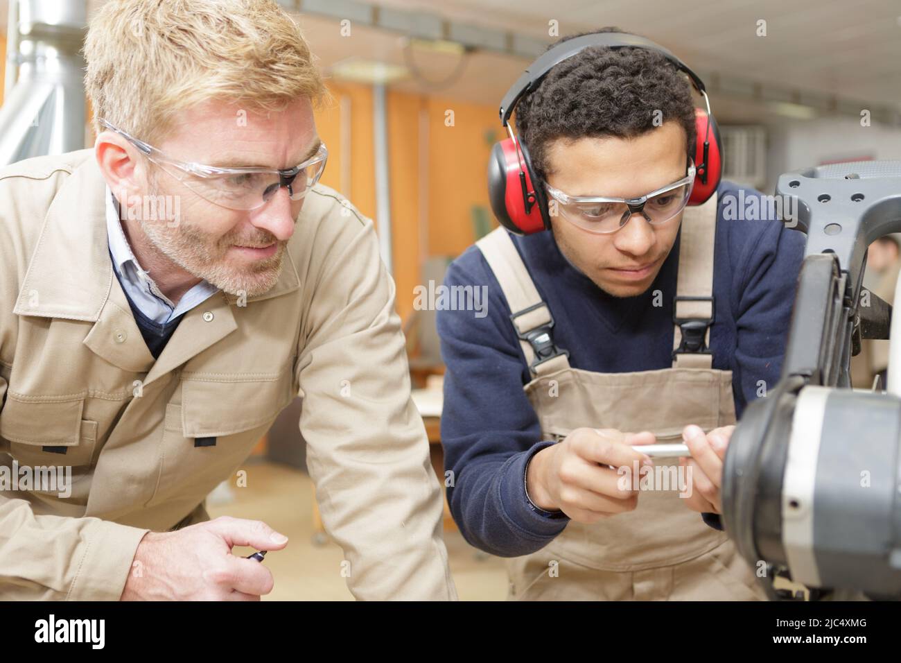 carpentry apprentice working under supervision Stock Photo Alamy