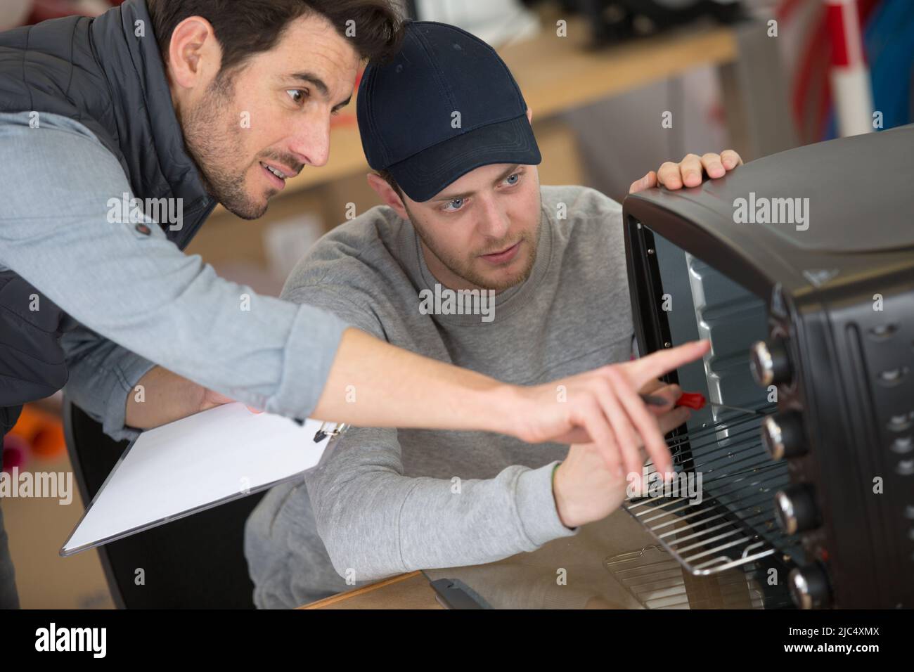 apprentice engineer learning how to repair oven Stock Photo Alamy