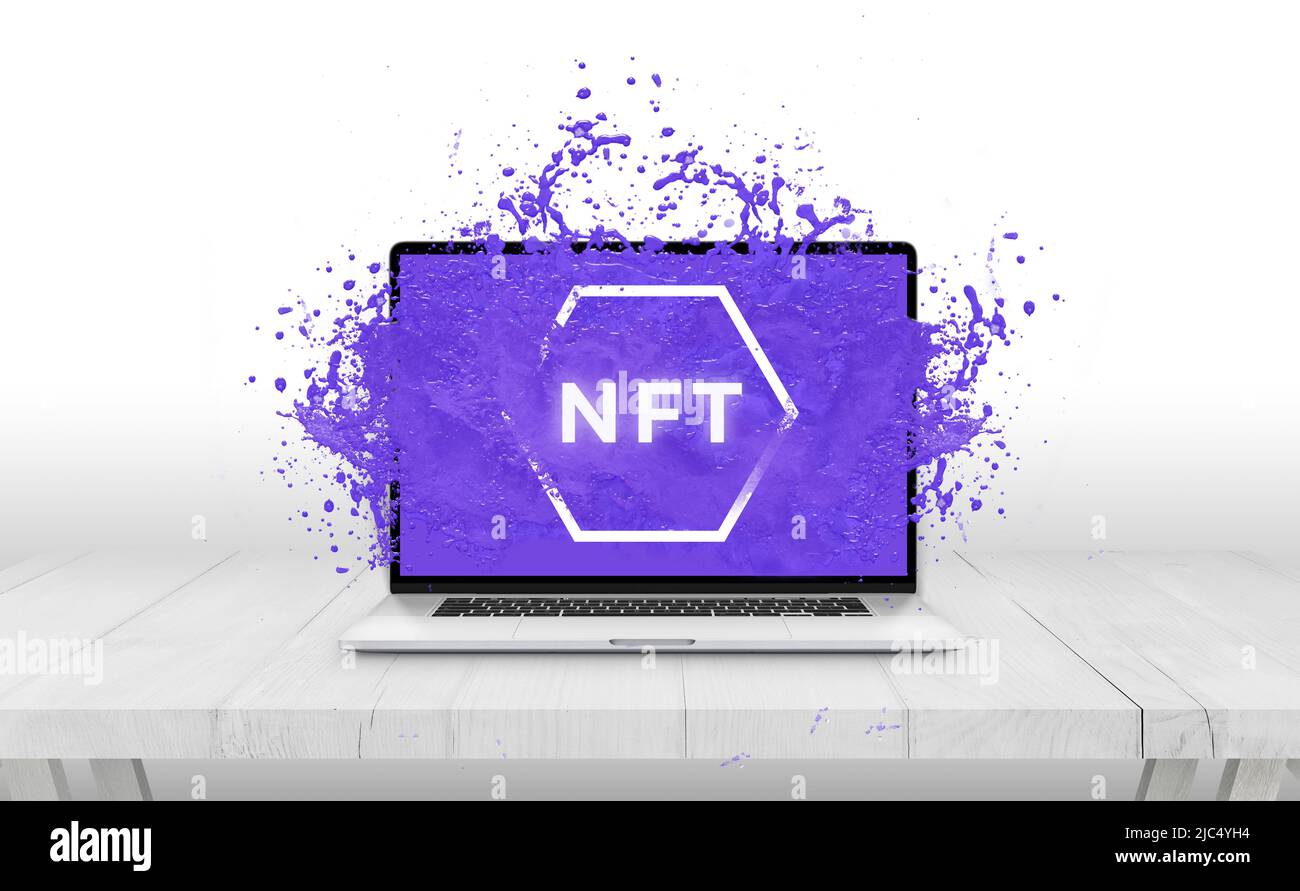 NFT non-fungible token text comes out with purple liquid from laptop display concept Stock Photo