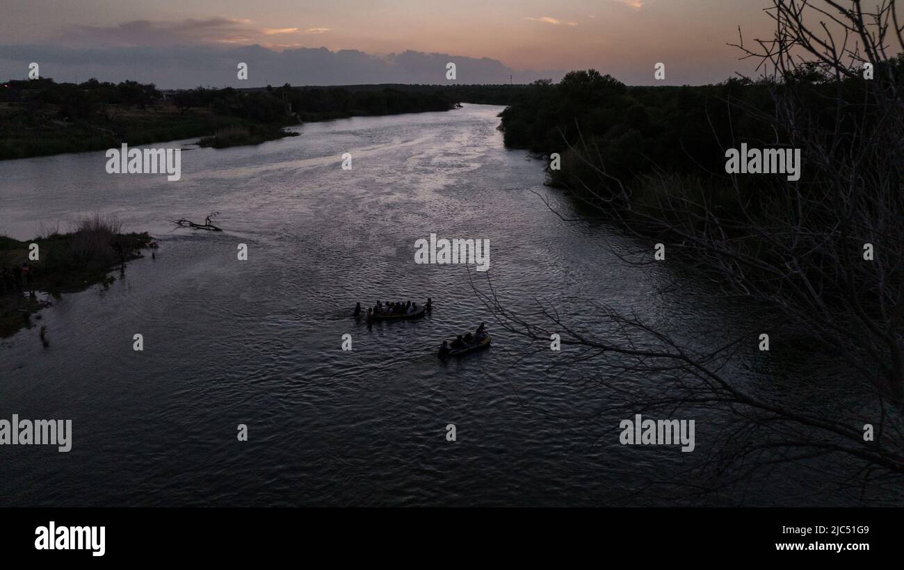 Smugglers pull rafts full of asylum seeking migrants from Central and South America across the Rio Grande river into Roma, Texas, U.S., June 9, 2022. Picture taken June 9, 2022. Picture taken with a drone.  REUTERS/Adrees Latif Stock Photo