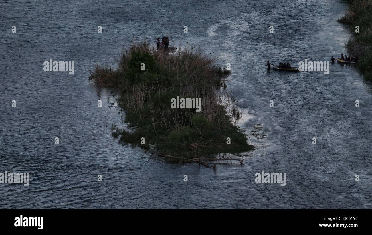 Asylum seeking migrants from Central and South America await on an island in the middle of the Rio Grande river near Mexico before continuing towards Roma, Texas, U.S., June 9, 2022. Picture taken June 9, 2022. Picture taken with a drone.   REUTERS/Adrees Latif Stock Photo