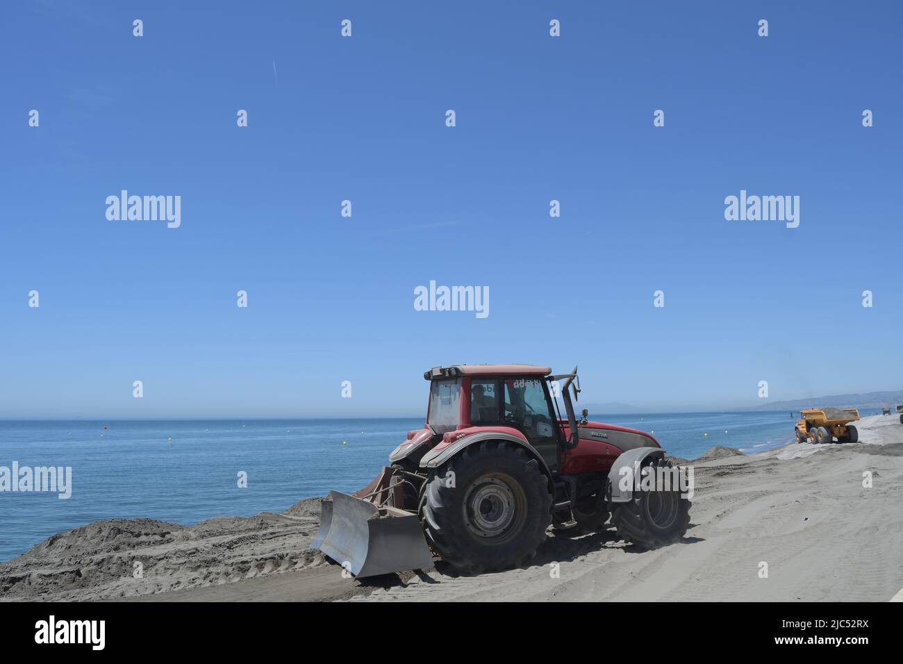Tractor machine nivelating sand in a beach Stock Photo Alamy