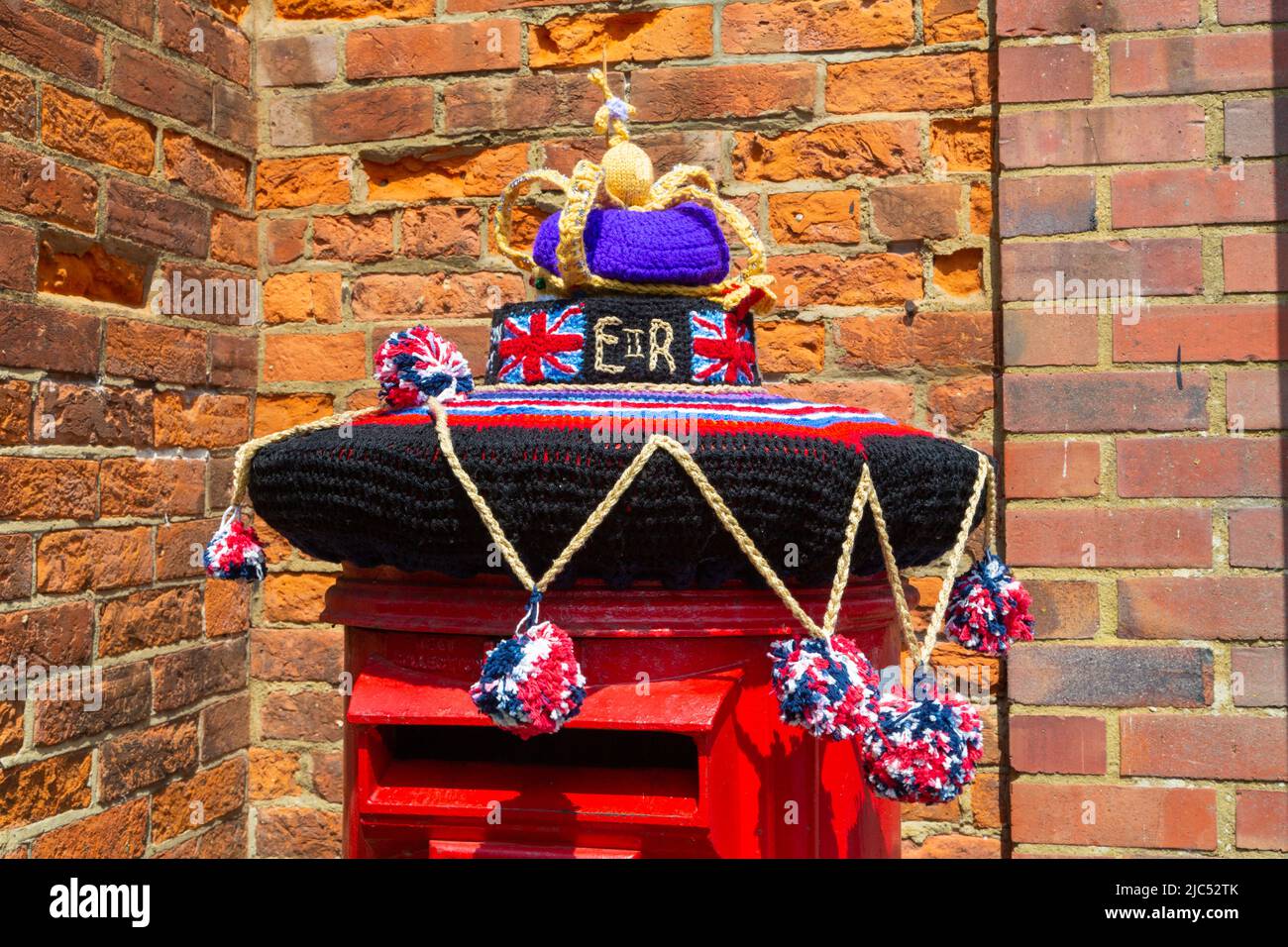 Yarn bombing, royal mail post box, crown, queens platinum jubilee weekend, hamstreet, kent, uk Stock Photo