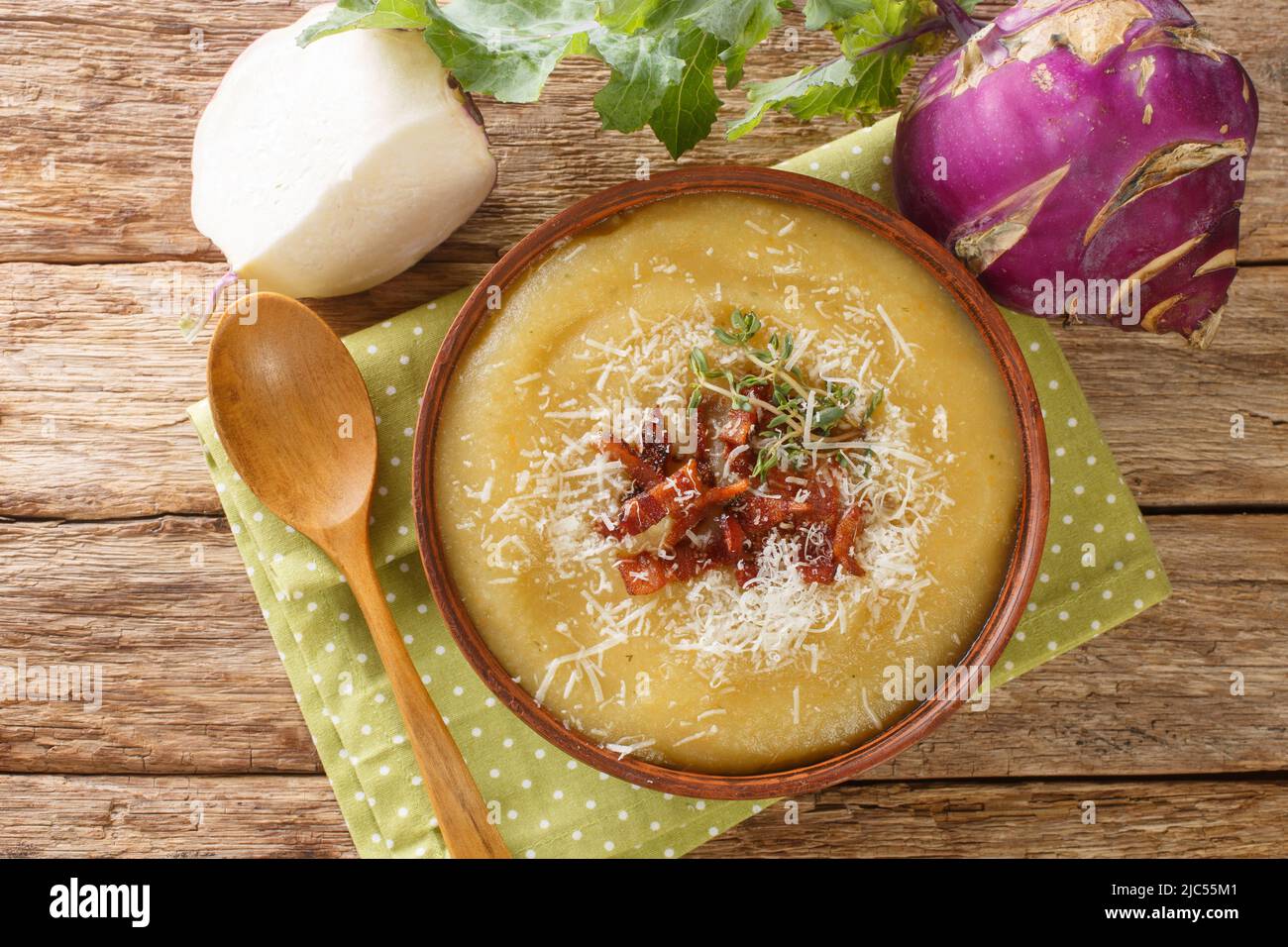 Homemade healthy pureed kohlrabi soup with bacon and parmesan cheese close-up in a bowl on the table. Horizontal top view from above Stock Photo