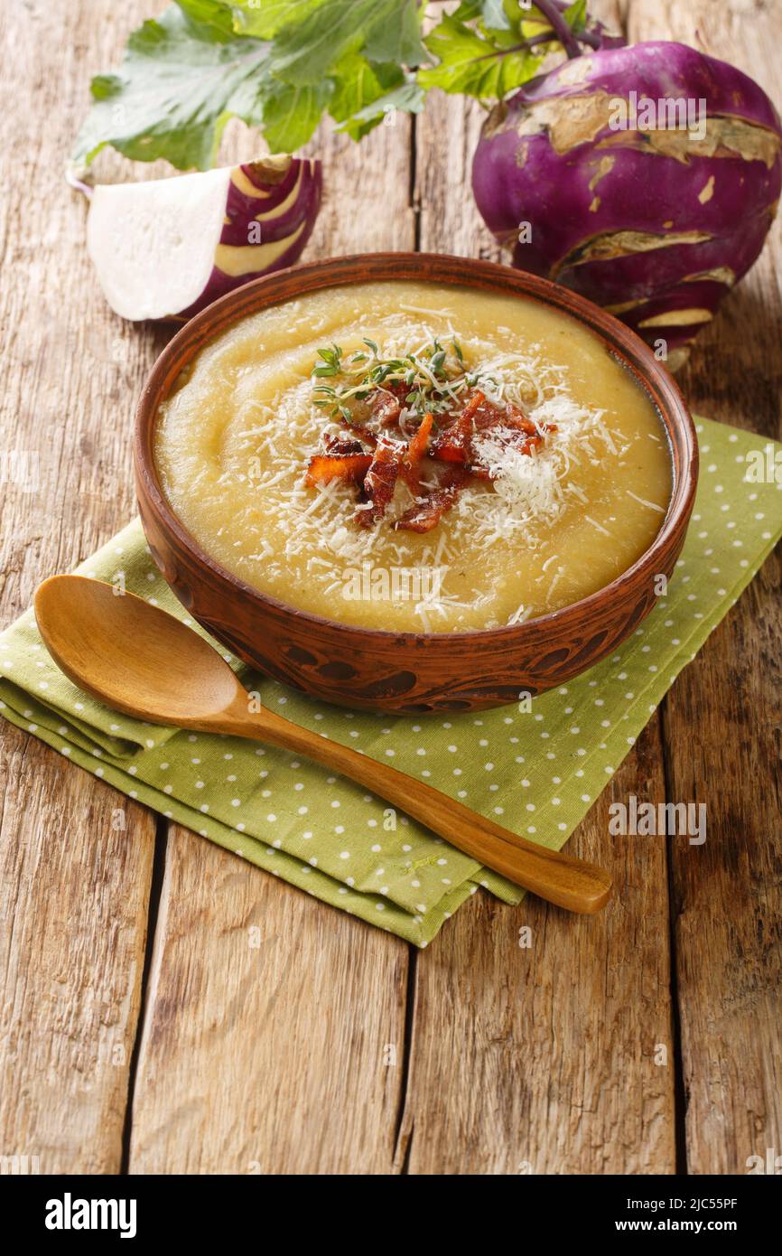 Creamy Kohlrabi Soup with bacon and parmesan cheese close-up in a bowl on the table. Vertical Stock Photo