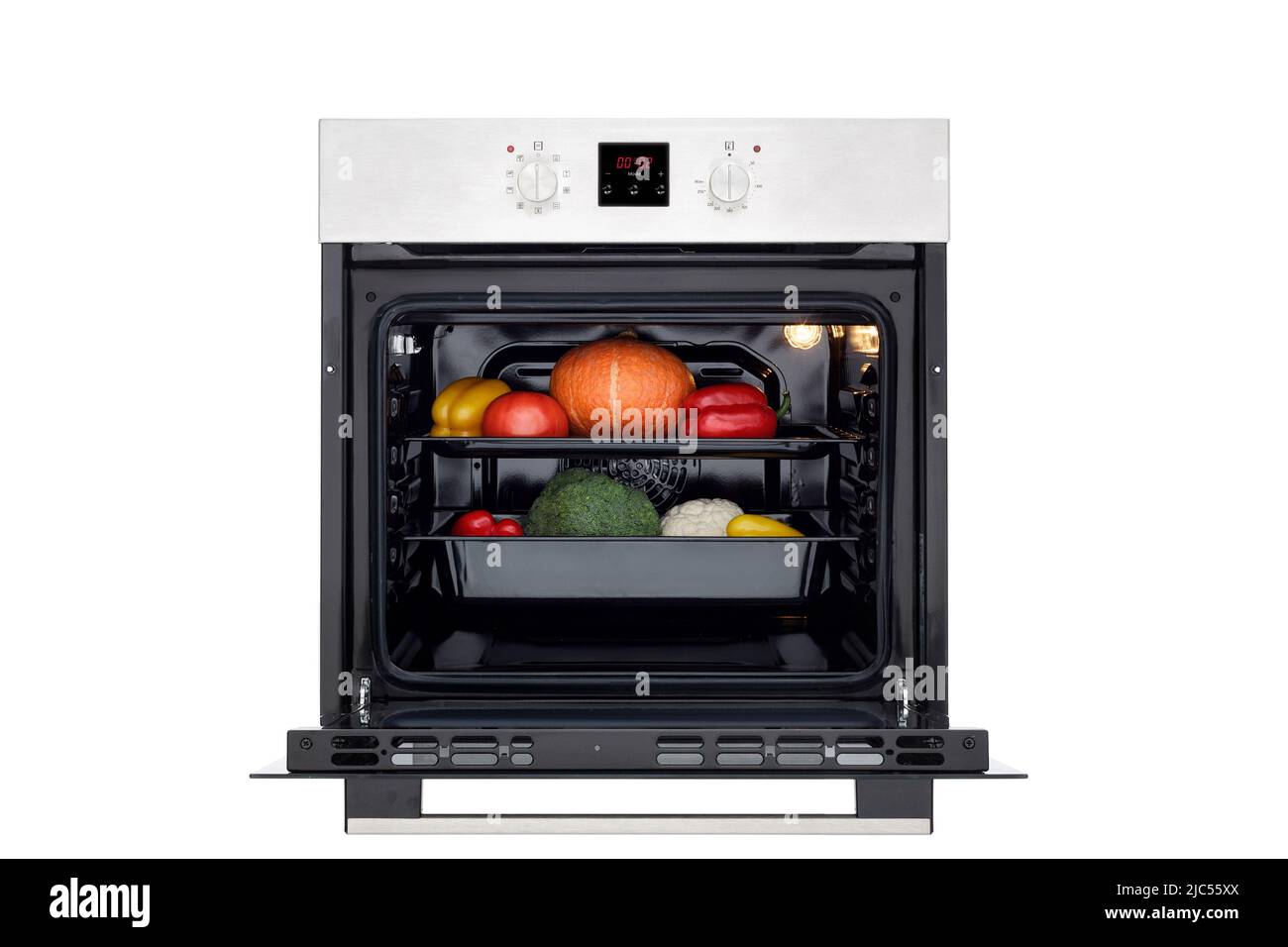 Electric oven with open door, lights on and vegetables for roasting. Front view. Isolated on