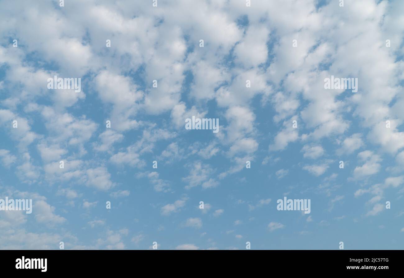 Blue sky with white patchy clouds. Also known as Altocumulus clouds. Stock Photo