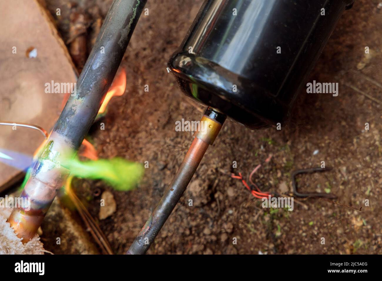 Green flame in copper pipe while joining pipe with fitting Stock Photo