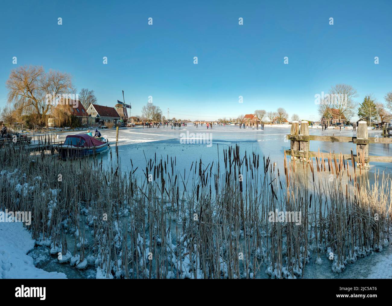 Scating on a frozen canal near a windmill called De Paauw *** Local Caption ***  Netherlands,windmill, water, winter, snow, ice, people, scaters,  ,Na Stock Photo