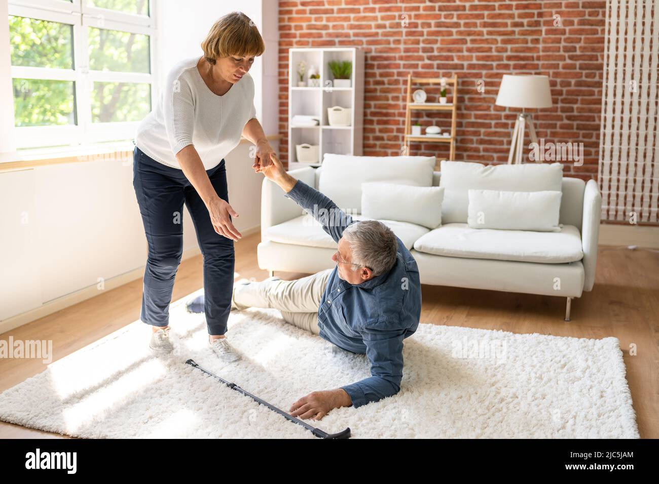 Slip And Fall Risk. Helping Woman Stock Photo - Alamy