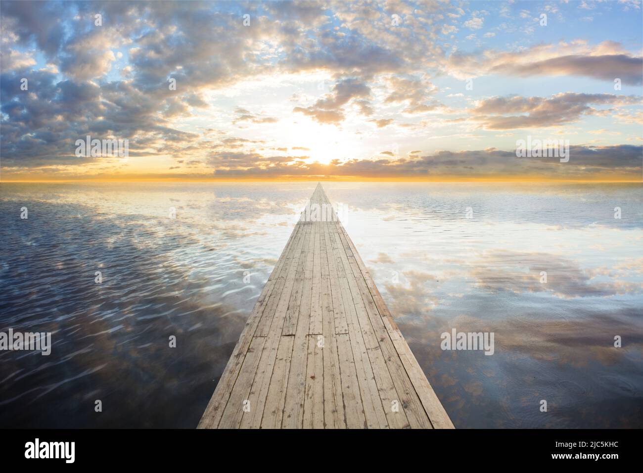 Wooden bridge on the sea which has walk way for travel with beautiful sky and sunshine background. Stock Photo