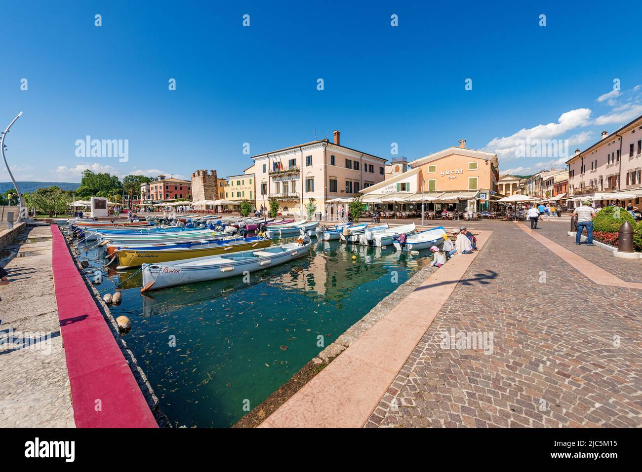 Small port of the village of Bardolino with boats moored. Tourist resort on the coast of Lake Garda (Lago di Garda). Verona province, Veneto, Italy. Stock Photo