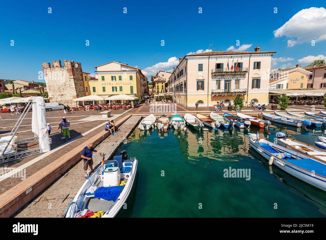 Small port of the village of Bardolino with boats moored. Tourist resort on the coast of Lake Garda (Lago di Garda). Verona province, Veneto, Italy. Stock Photo