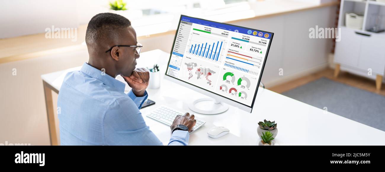Businessman Looking At Dashboard Analyzing KPI Graph On Computer Stock Photo