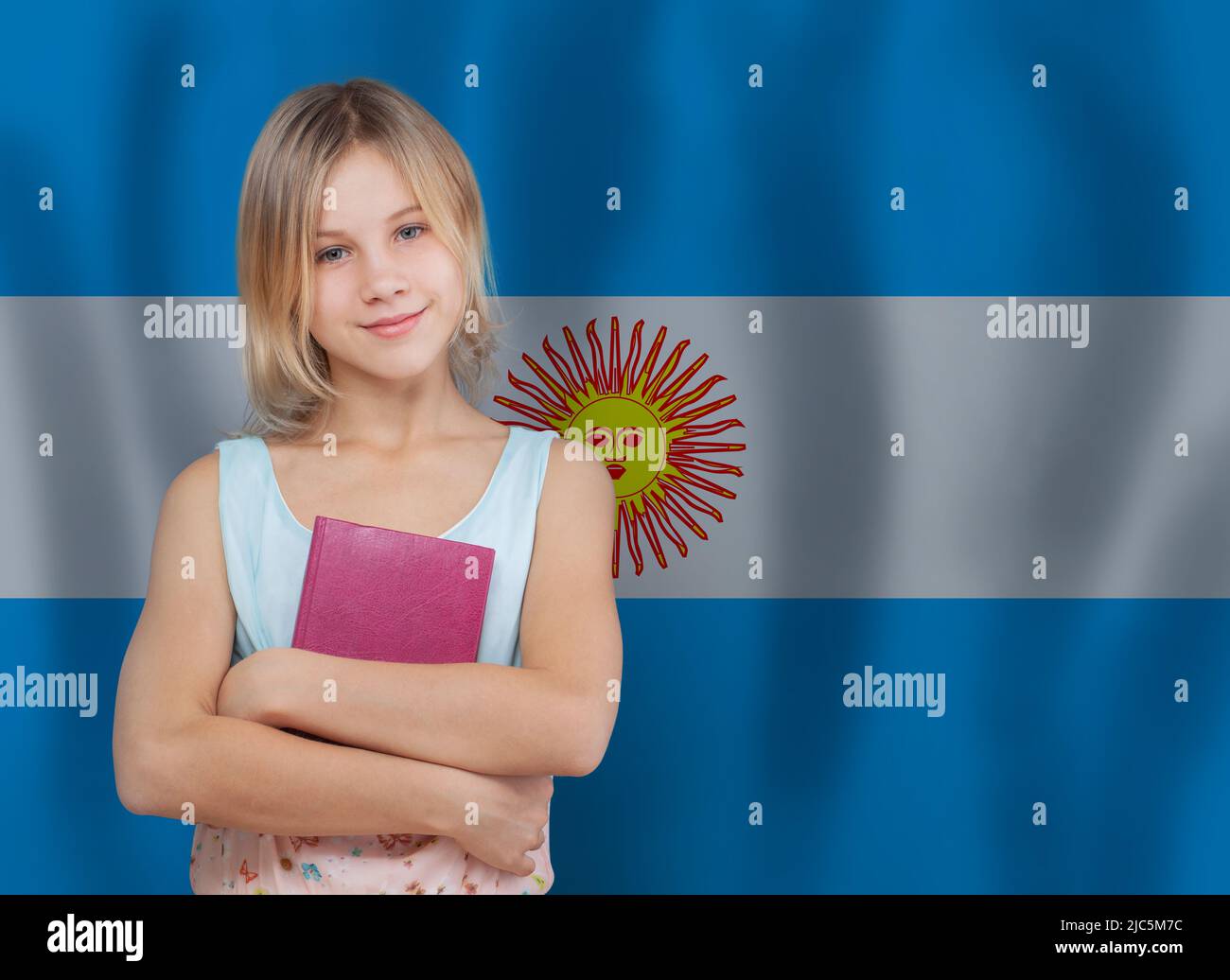 Cute young student girl with book on Argentine flag background