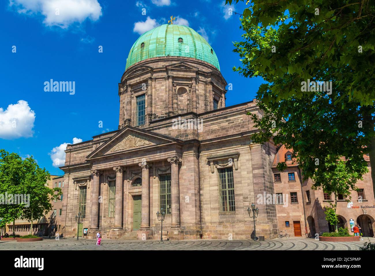 Lovely view of the St. Elizabeth's church with a high portal framed by columns with pilasters and a pediment, on a sunny summer day in Nuremberg,... Stock Photo