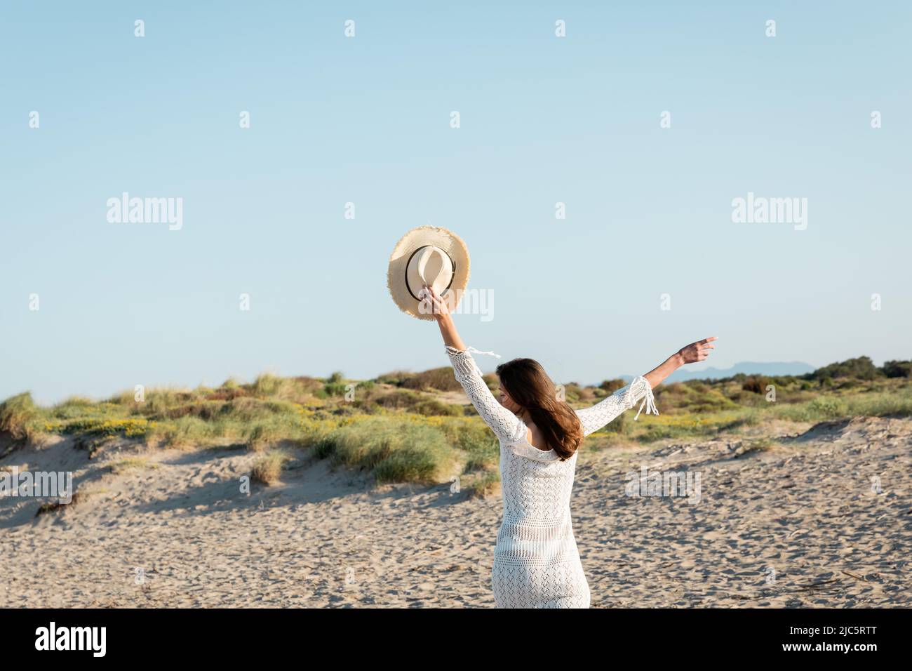 Young woman holding sun hat while running on beach Stock Photo - Alamy